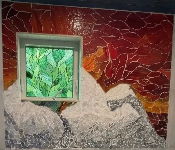 Alpine sunset mosaic mural around a stained-glass window, cropped to the artwork